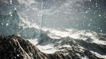 kraftigt snöfall, fokuserat på snöflingorna, bergen i bakgrunden video