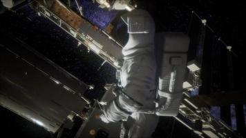 astronauta fora da estação espacial internacional em uma caminhada espacial