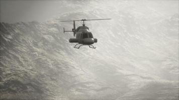 Helicóptero volador en cámara lenta extrema cerca de montañas con niebla video