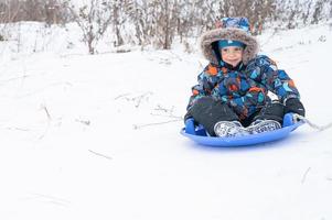 tobogán cabalgando por la actividad de invierno para niños foto