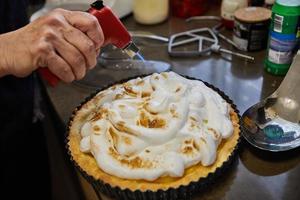 chef quema la crema en el pastel de pasiflora. cocina gourmet francesa foto