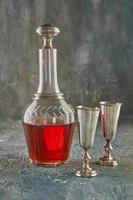 bodegón, vidrio antiguo y decantador de plata con vino y dos copas foto