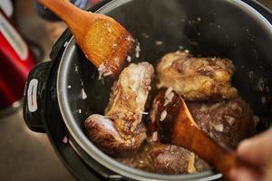 El osobuco con carne de huso se fríe en olla a presión y se mezcla con espátulas de madera. cocina gourmet francesa foto