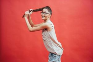 Beautiful young woman in glasses. On a beautiful red background. Beauty, fashion. Makeup. photo