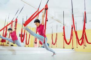 Young women doing yoga exercise or aerial yoga antigravity in the studio. photo