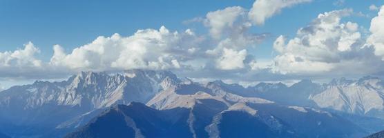 Fantastic snow-capped mountains in the beautiful cumulus clouds photo