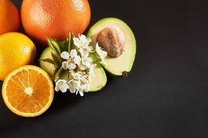 pomelo, naranja y aguacate, aislados en un fondo negro foto