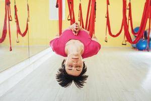 young woman making antigravity yoga exercises photo