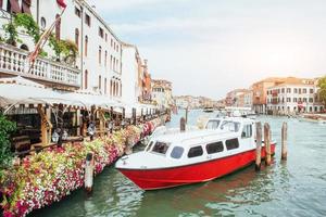 canal de agua verde con góndolas y coloridas fachadas de antiguos edificios medievales al sol en venecia, italia.