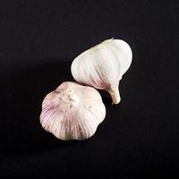 2 fresh garlic bulbs on a black background. photo