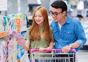 recién casados asiáticos comprando comestibles en el supermercado foto