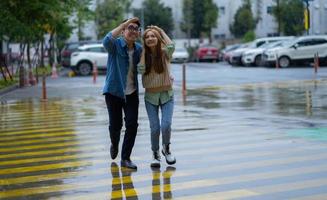 Young Asian couple walking in the rain photo