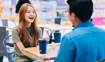 Young Asian couple having lunch together in cafe photo