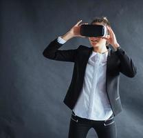 mujer feliz en segundo plano en el estudio obtiene la experiencia de usar auriculares de realidad virtual vr-glasses foto