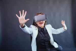 mujer feliz con fondo negro en el estudio obtiene la experiencia de usar auriculares de realidad virtual vr-glasses. foto