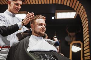 Men's hairstyling and haircutting in a barber shop or hair salon. photo