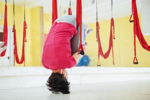 Young beautiful woman practicing yoga Fly with a hammock in studio. photo