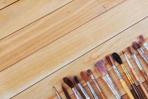 Paintbrushes and art tools on a wooden table background
