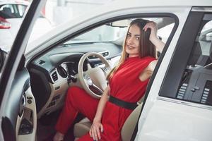 woman in car indoor keeps wheel turning around smiling looking at passengers in back seat idea taxi driver against sunset rays Light shine sky Concept of exam Vehicle - second home the girl photo