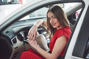 woman in car indoor keeps wheel turning around smiling looking at passengers in back seat idea taxi driver against sunset rays Light shine sky Concept of exam Vehicle - second home the girl