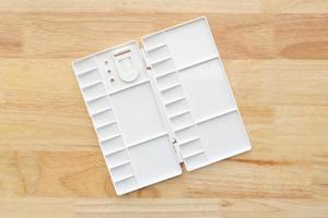 White watercolor palette. Empty watercolor tray isolated on wood background. photo