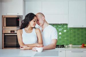 Happy young couple having coffee in the kitchen photo