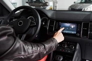 Smart car and internet of things IOT concept. Finger point to car 's console and icons popup out of screen photo