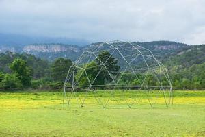 Metal structure against a background of green grass and blue sky. photo