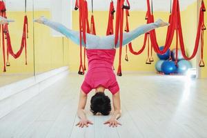 young woman making antigravity yoga exercises photo