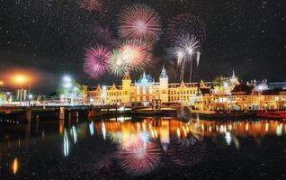 hermosa vista nocturna tranquila de la ciudad de amsterdam. fuegos artificiales coloridos en el fondo del cielo negro. tarjeta de felicitación con foto. efecto de luz bokeh, filtro suave