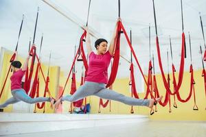 Young women doing yoga exercise or aerial yoga antigravity in the studio. photo