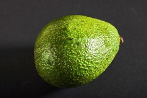 Fresh delicious avocado isolated on a black background photo