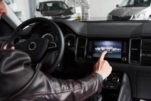 Smart car and internet of things IOT concept. Finger point to car 's console and icons popup out of screen photo