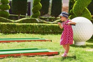 Child playing mini - golf on artificial grass. photo