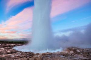 Strokkur geyser eruption in Iceland. Fantastic colors shine through the steam. photo