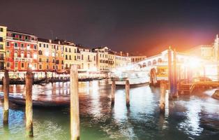 paisaje de la ciudad. puente de rialto ponte di rialto en venecia, italia por la noche. muchos turistas visitando la belleza de la ciudad durante todo el año foto