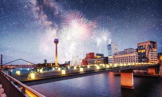 Beautiful calm night view of Amsterdam city. Colorful fireworks on the black sky background. Photo greeting card.