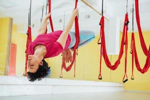 Young women doing yoga exercise or aerial yoga antigravity in the studio. photo
