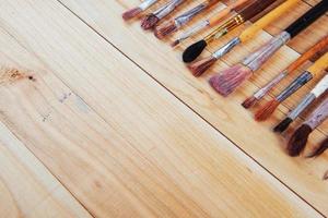 Bunch of old artist paintbrushes on wooden rustic table