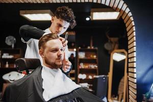 Men's hairstyling and haircutting in a barber shop or hair salon. photo