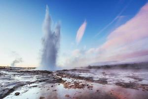 erupción del géiser strokkur en islandia. Fantásticos colores brillan a través del vapor. foto