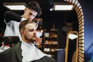 Men's hairstyling and haircutting in a barber shop or hair salon. photo