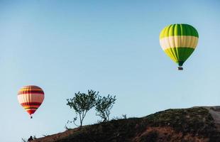 Hot air balloon flying over rock landscape at Cappadocia Turkey. Valley, ravine, hills, located between the volcanic mountains photo