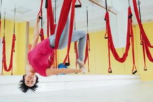 young woman making antigravity yoga exercises photo