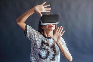 Happy woman gets experience of using VR-glasses virtual reality headset. photo