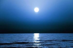 A blue night sky over the sea photo