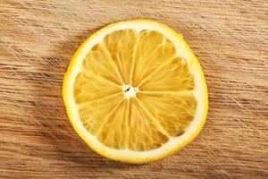 a slice of lemon, isolated on a wooden background photo