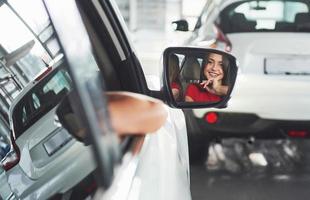 woman in car indoor keeps wheel turning around smiling looking at passengers in back seat idea taxi driver against sunset rays Light shine sky Concept of exam Vehicle - second home the girl photo