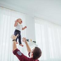 Father throwing hand high air joyful daughter. photo