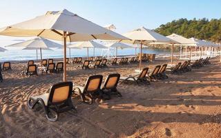 Scenic view of private sandy beach with sun beds from the sea and the mountains. Amara Dols Vita Luxury Hotel. Resort. Tekirova Kemer. Turkey. photo